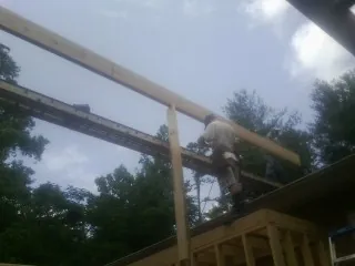 Carpenter setting a ridge beam over a new addition frame — Ice Dam Removal by Roofing Brothers in Maquoketa
