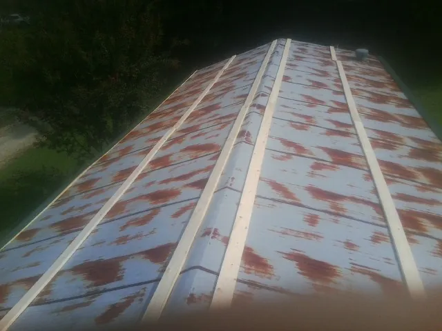 Rusted metal roof panels with new wood purlins before replacement — Storm Damage Roof Repair in Maquoketa by Roofing Brothers