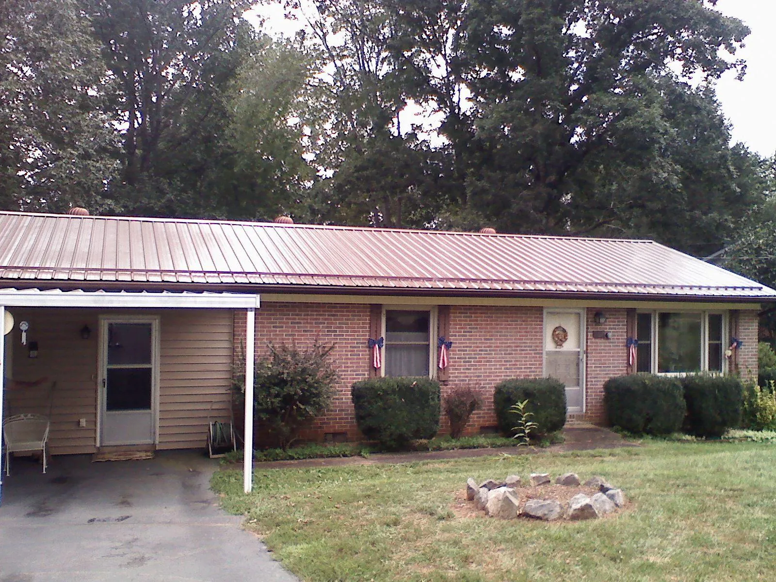 Bronze metal roof and carport on a brick ranch home — Roof Repair work by our crew in Maquoketa